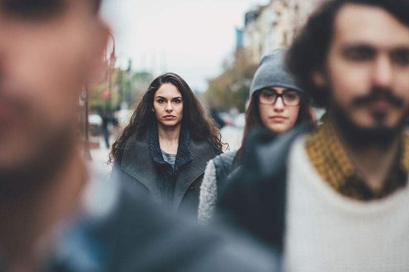 A young woman walks down a crowded street